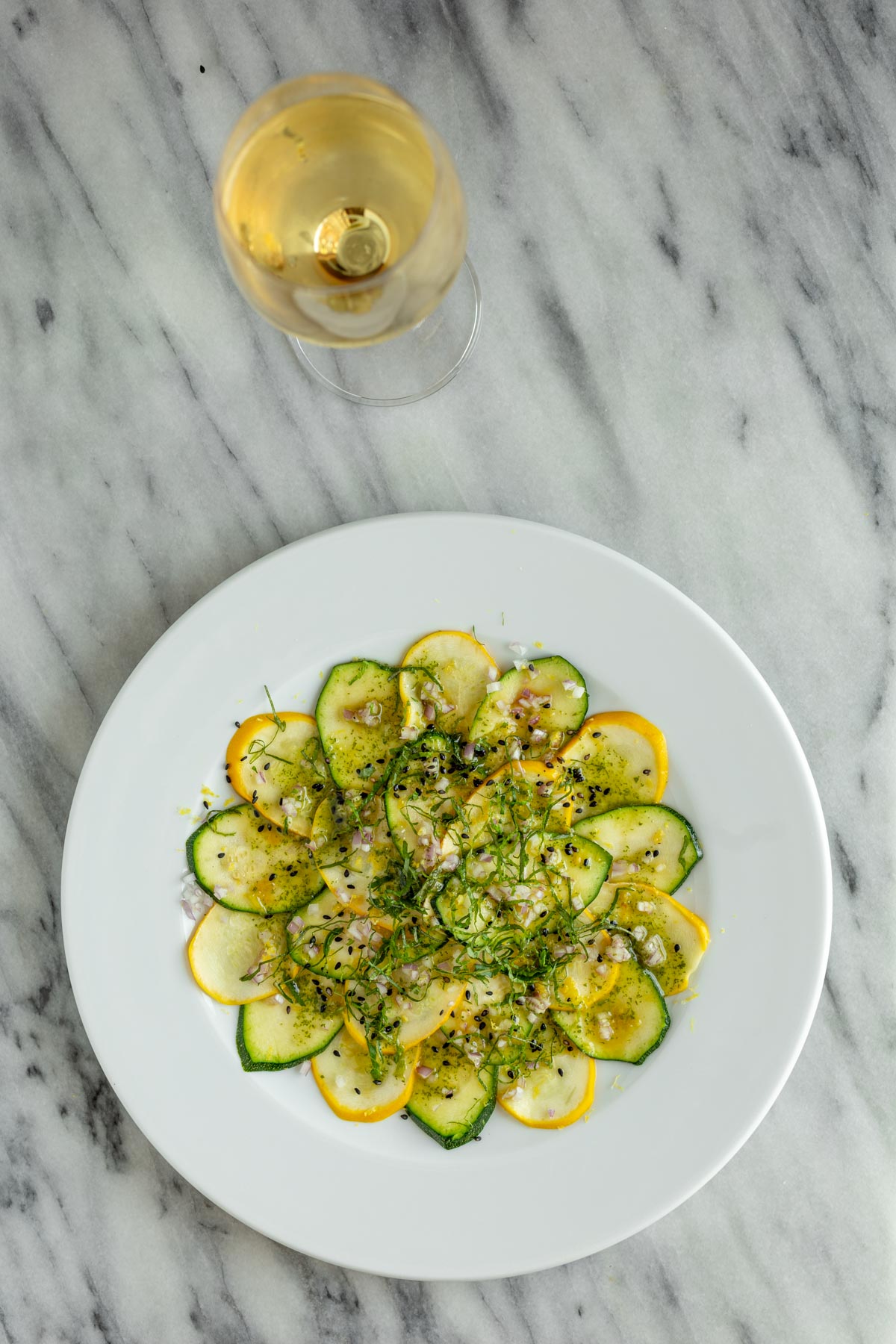 zucchini carpaccio salad on white plate with white eine
