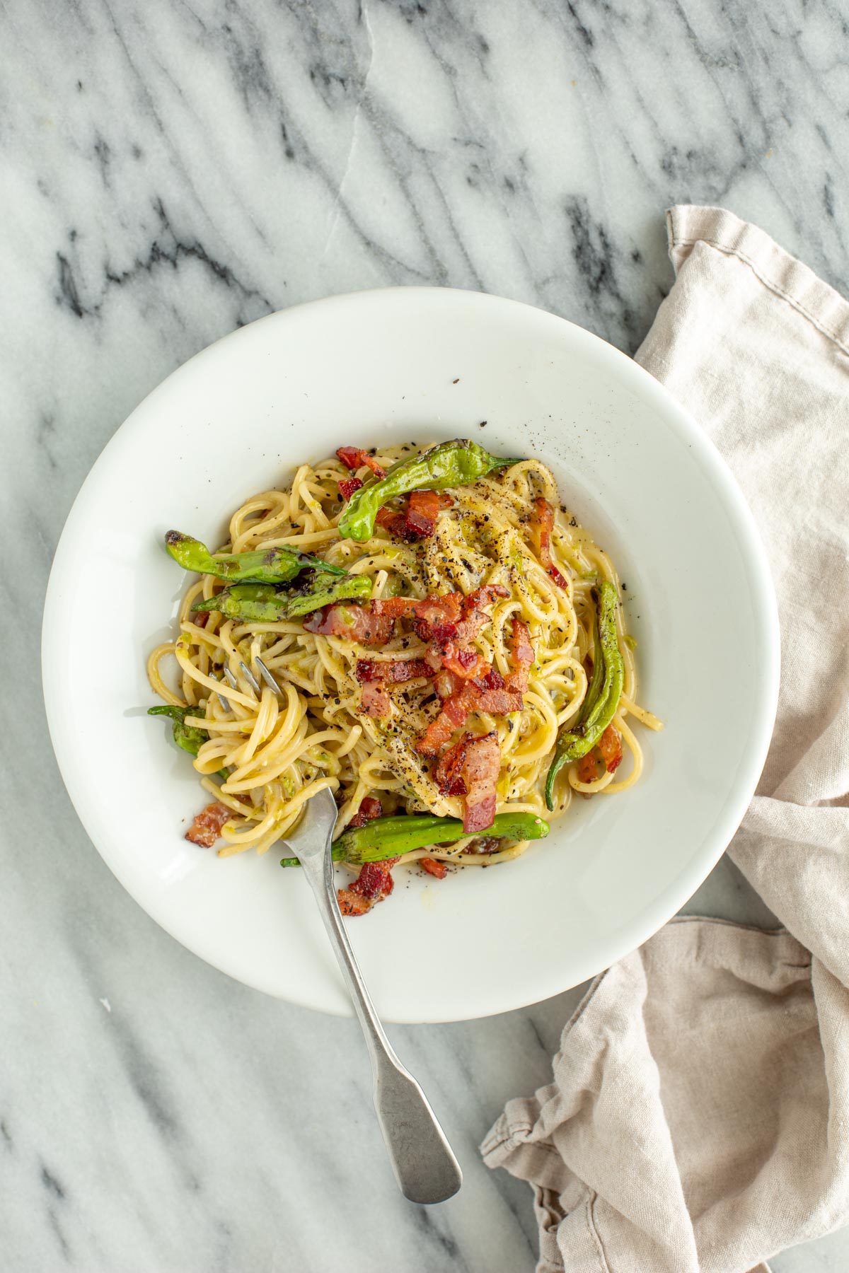 Spaghetti Miso Carbonara with Shishito Peppers on White Pasta Bowl with Fork