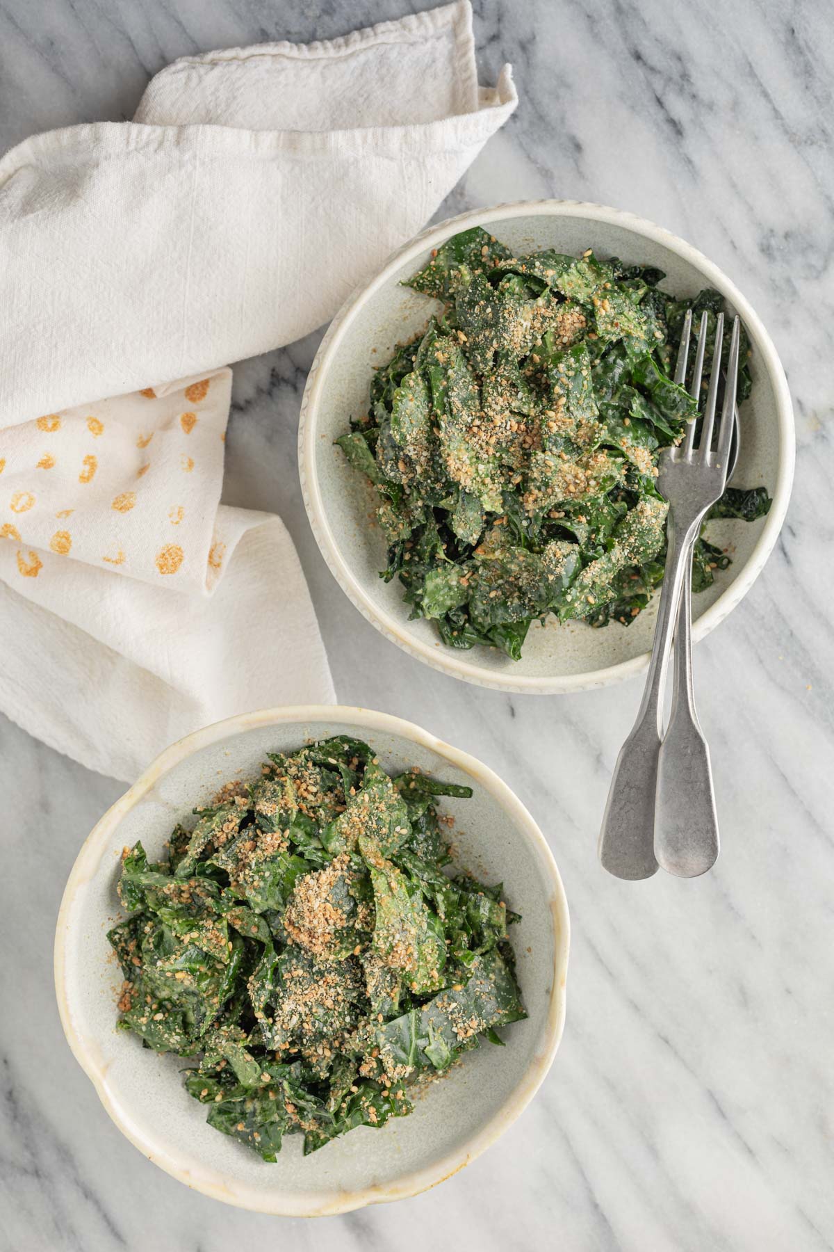kale salad with miso tahini dressing in a bowl with a napkin